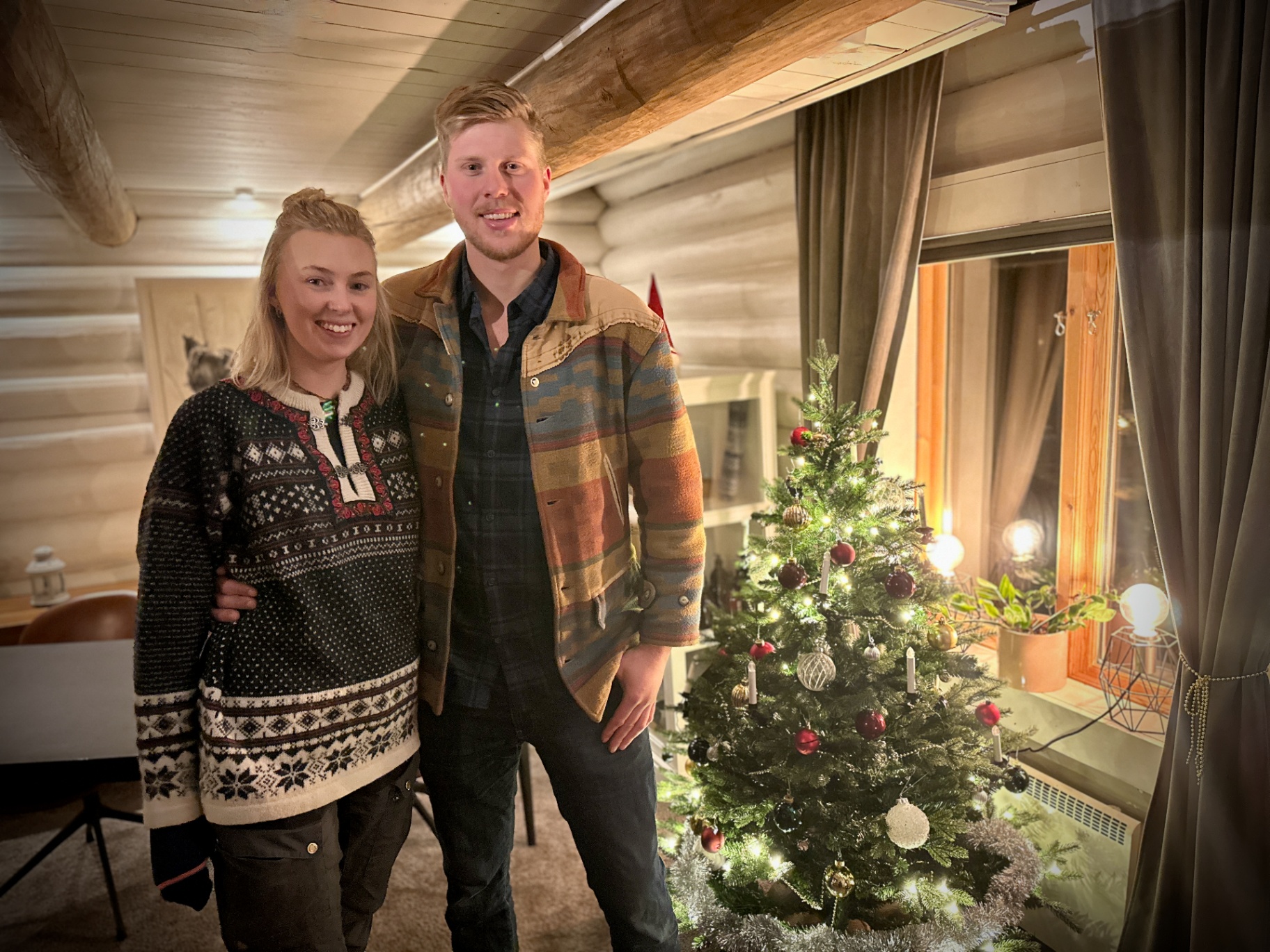 Timber cabin at Christmas, warmly lit interior